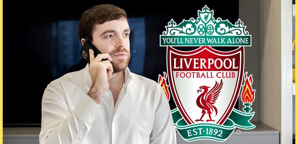 Man on phone with Liverpool FC logo in background
