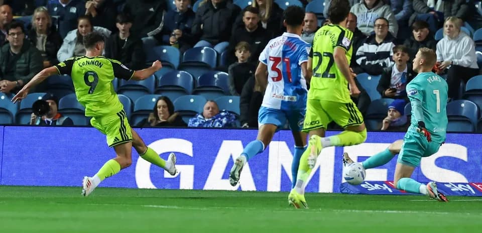 Player shooting on goal while goalkeeper prepares to save