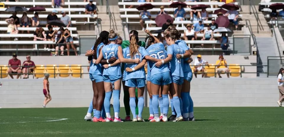 Soccer team huddling before match on field