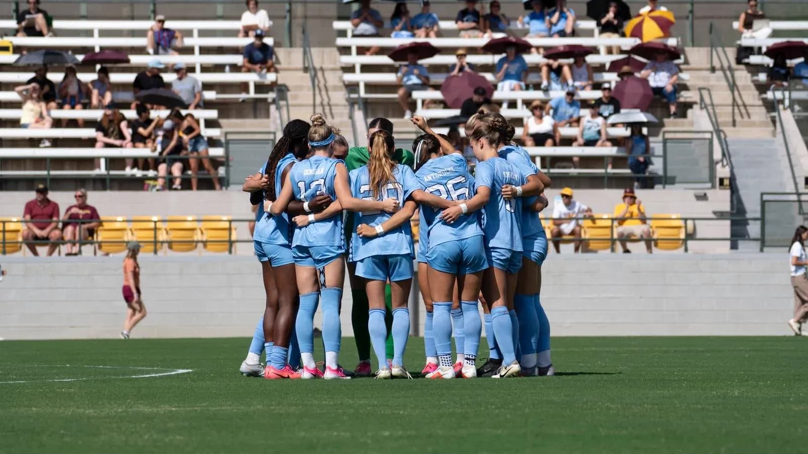 Soccer team huddling before match on field