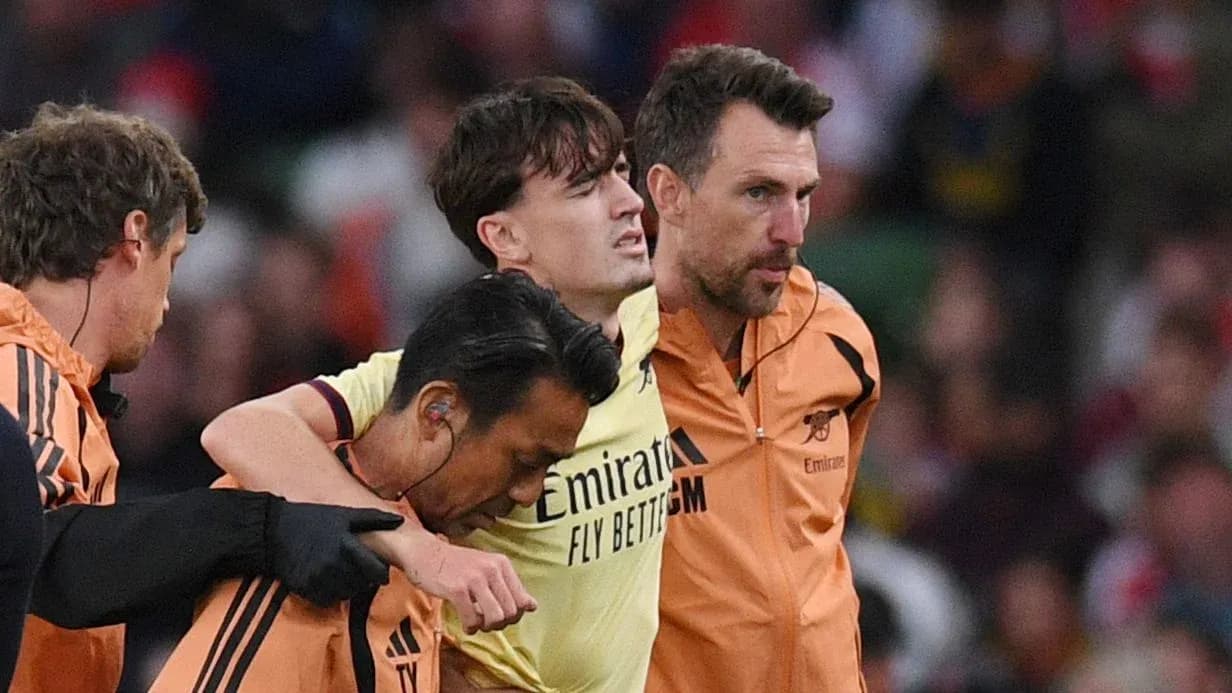 Player being assisted off the field by staff