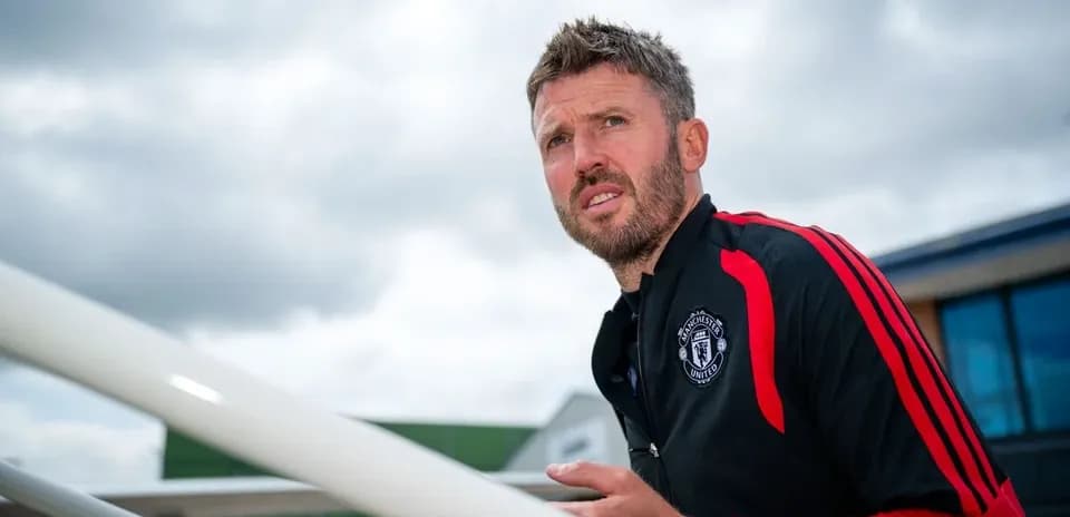 Manchester United coach observing training session outdoors