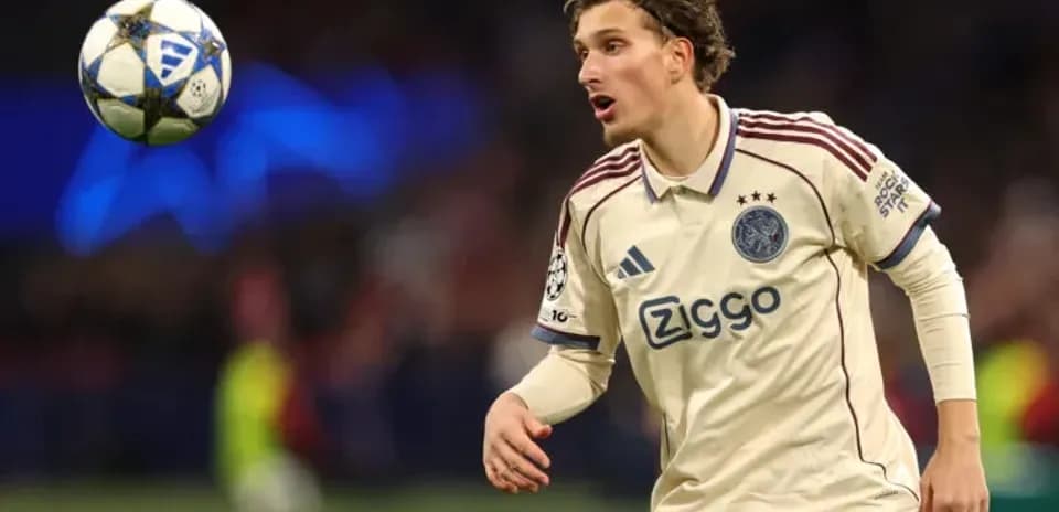 Player in Ajax jersey controlling a football