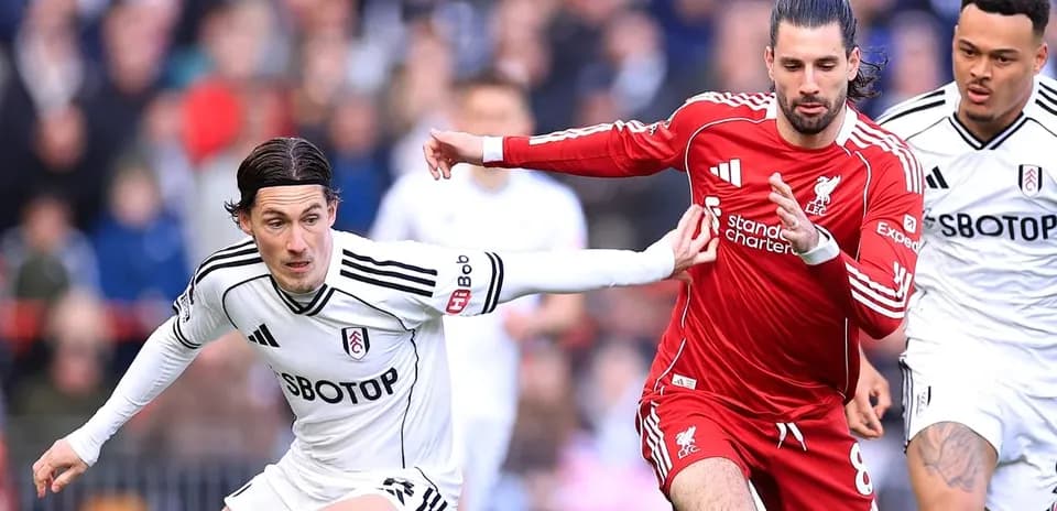 Players from Fulham and Liverpool competing for the ball