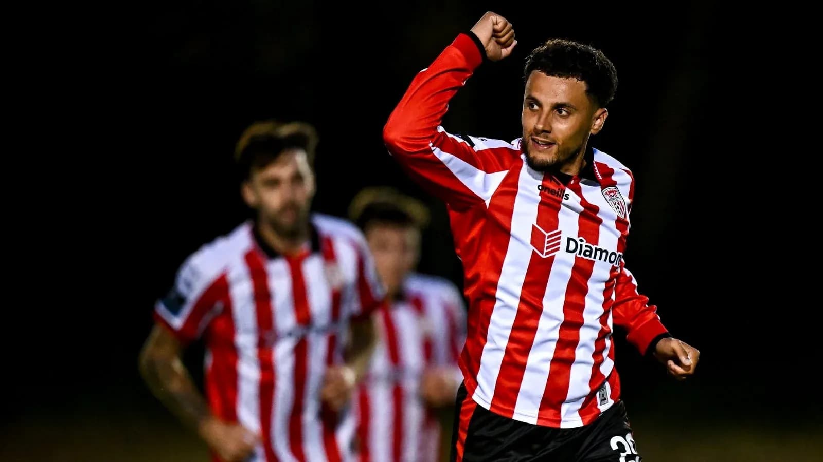Player celebrating a goal with teammates in background