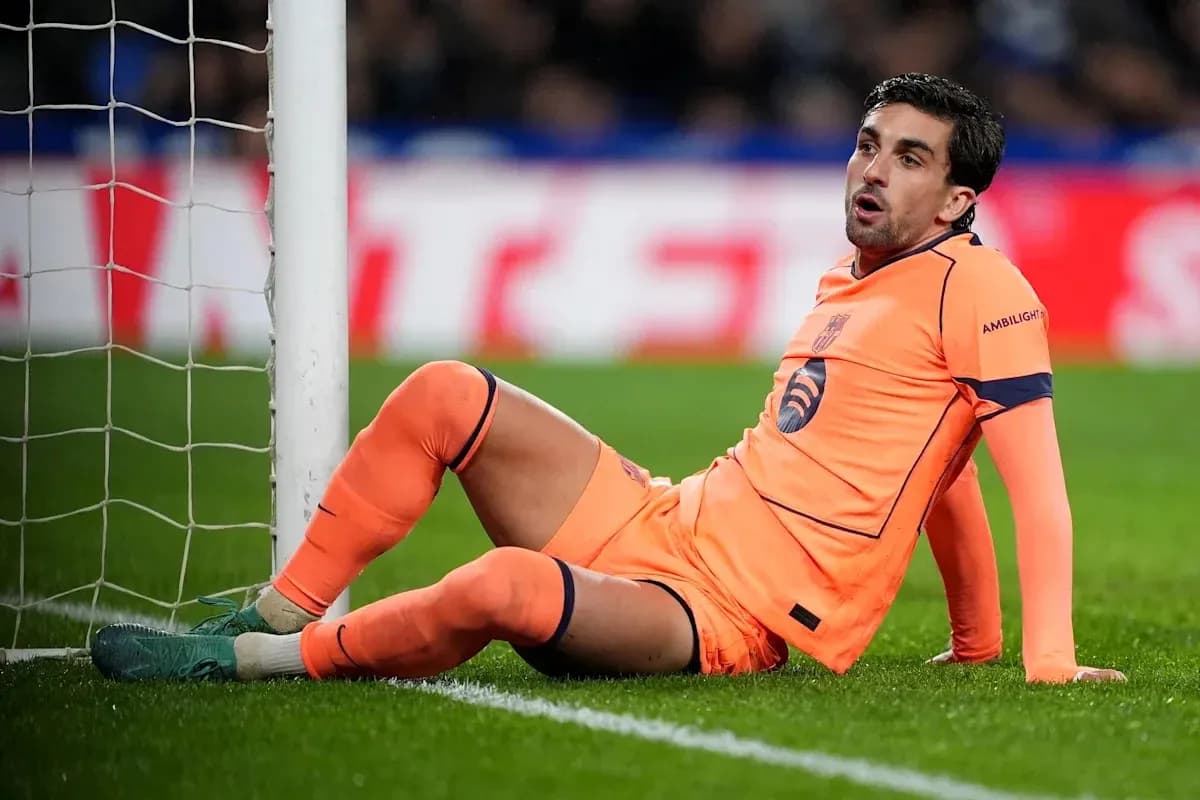 Goalkeeper sitting on the pitch near goalpost
