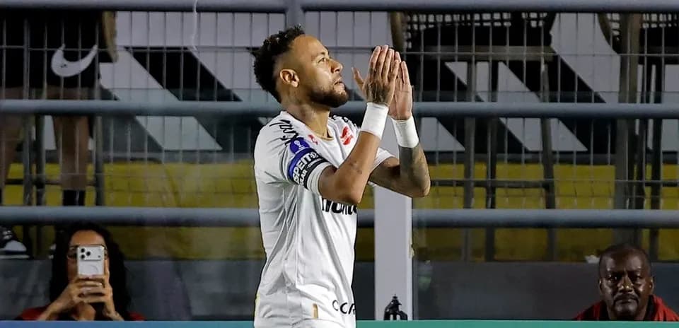 Neymar celebrating during match with fans in background