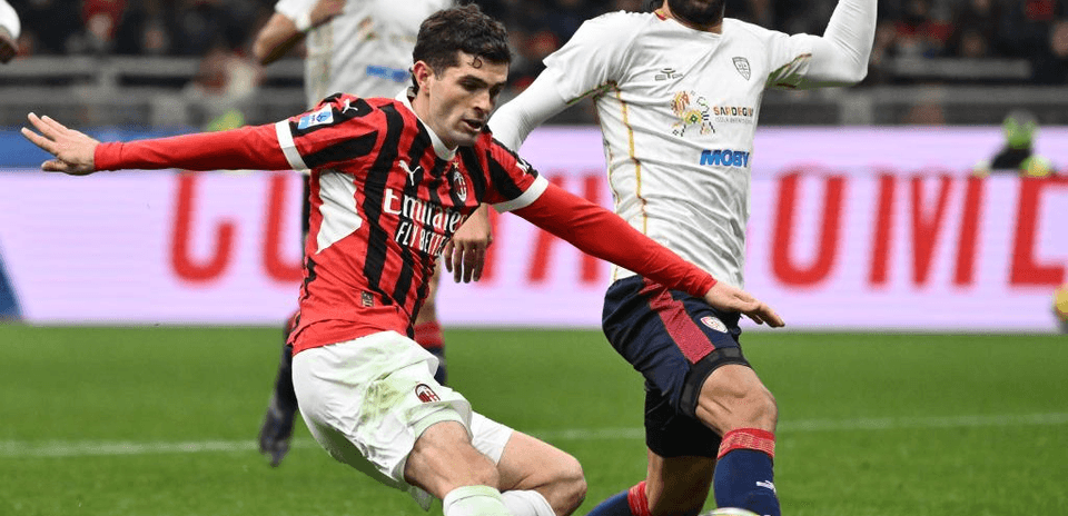 AC Milan player challenging Cagliari opponent