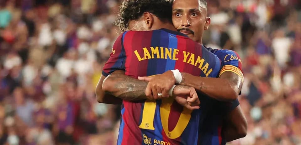 Two FC Barcelona players hugging on the field