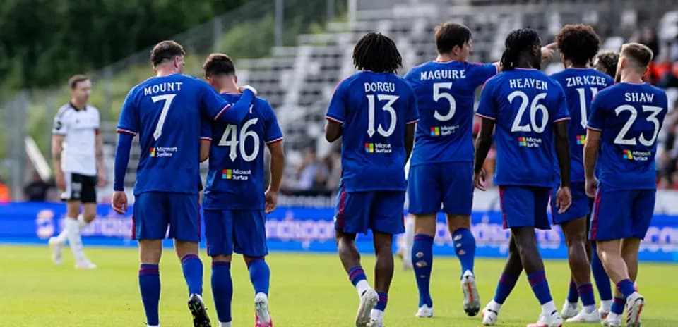 Players celebrating together in team jerseys on field