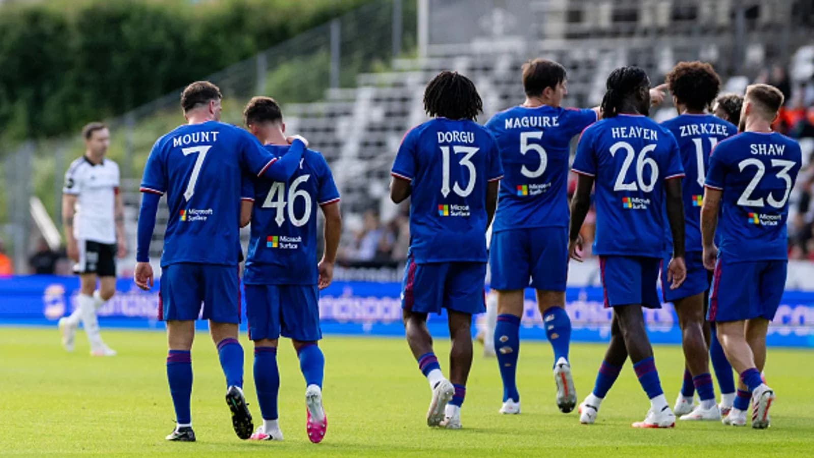 Players celebrating together in team jerseys on field