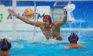 Goalkeeper attempting to block a water polo shot