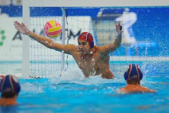 Goalkeeper attempting to block a water polo shot