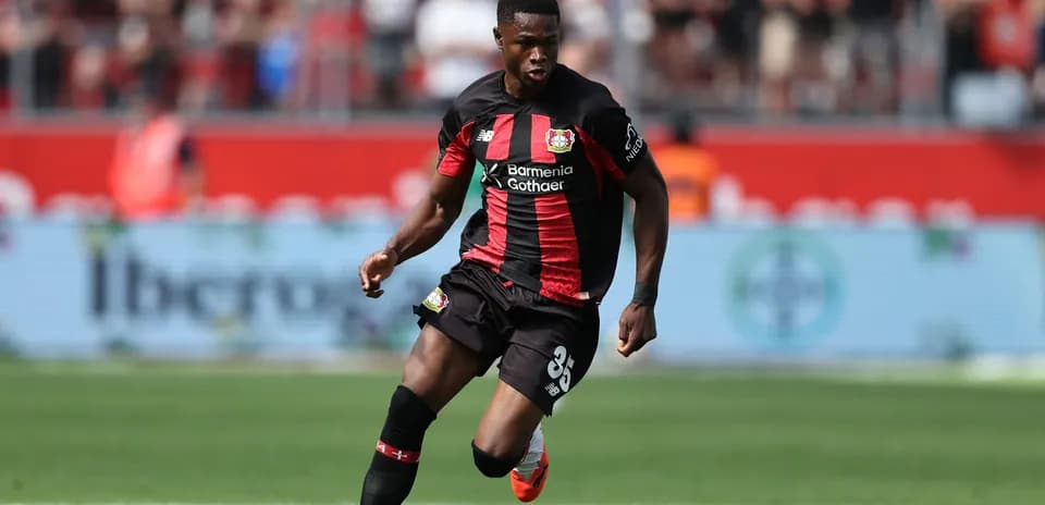 Player in Bayer Leverkusen kit dribbling the ball