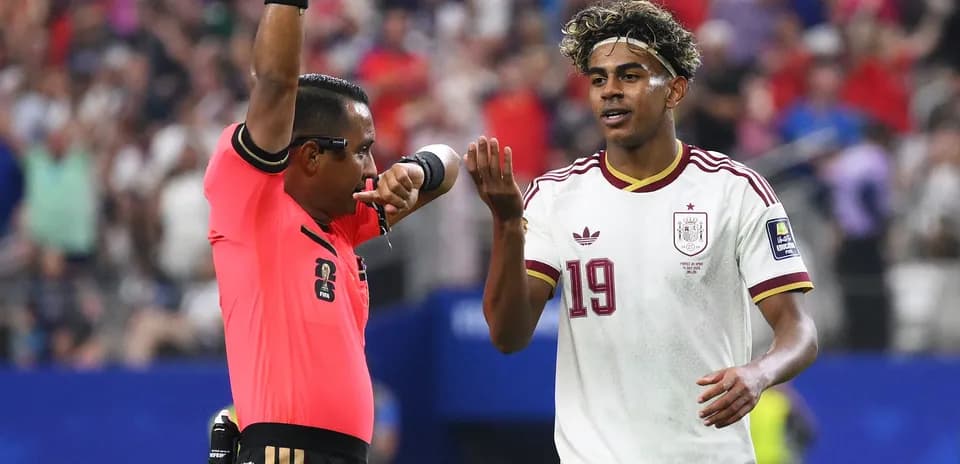 Referee issuing a card to Spanish player during match