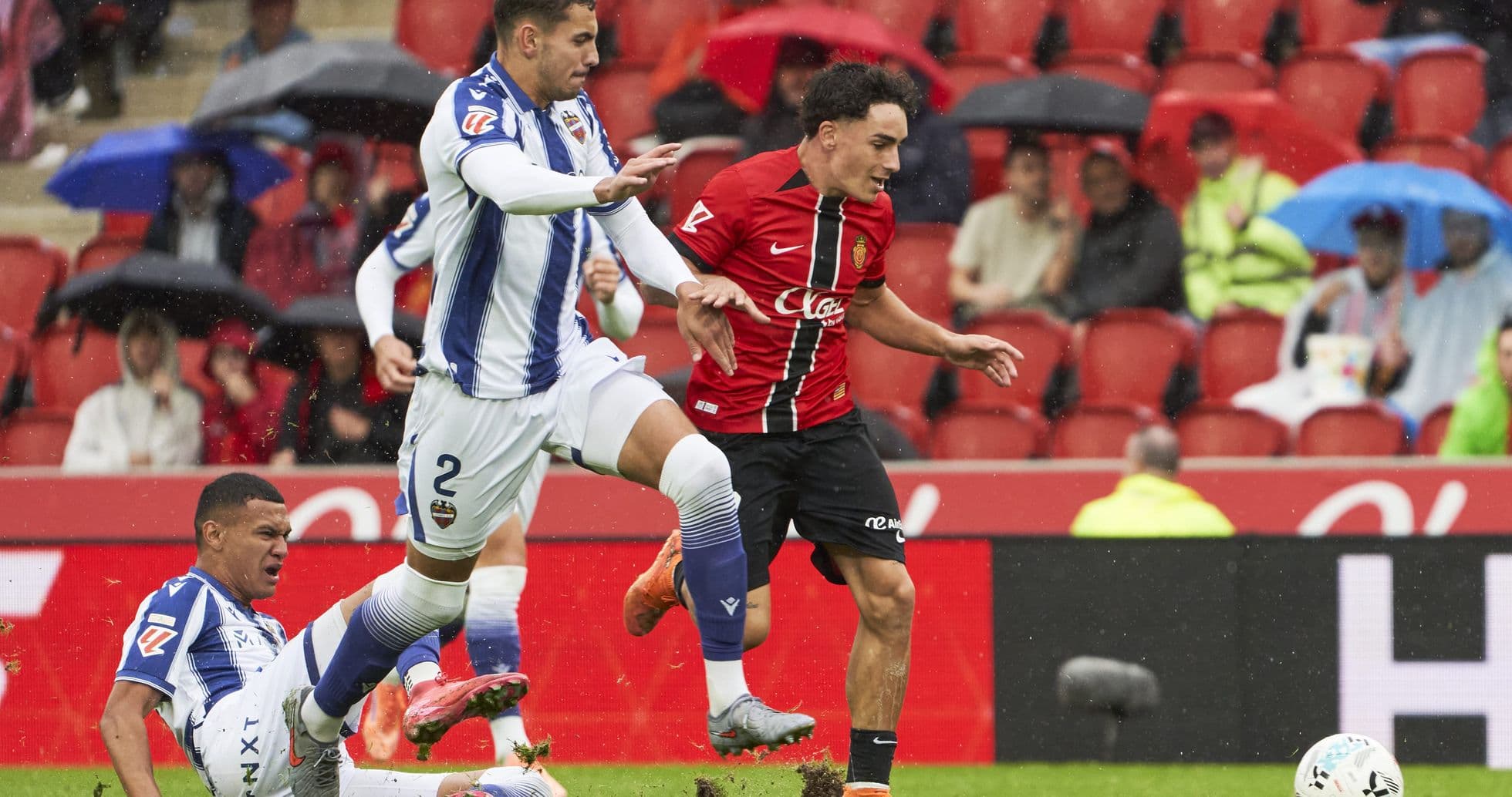 Levante player tackling Mallorca opponent during match