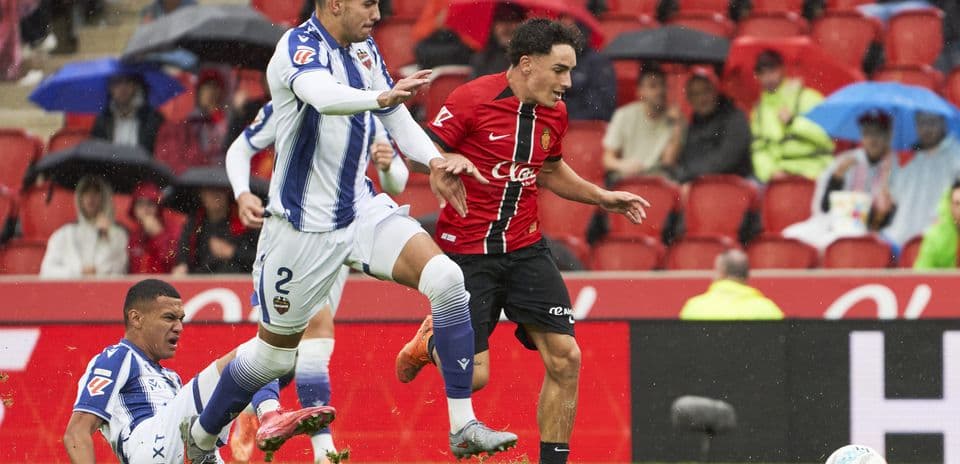 Levante player tackling Mallorca opponent during match