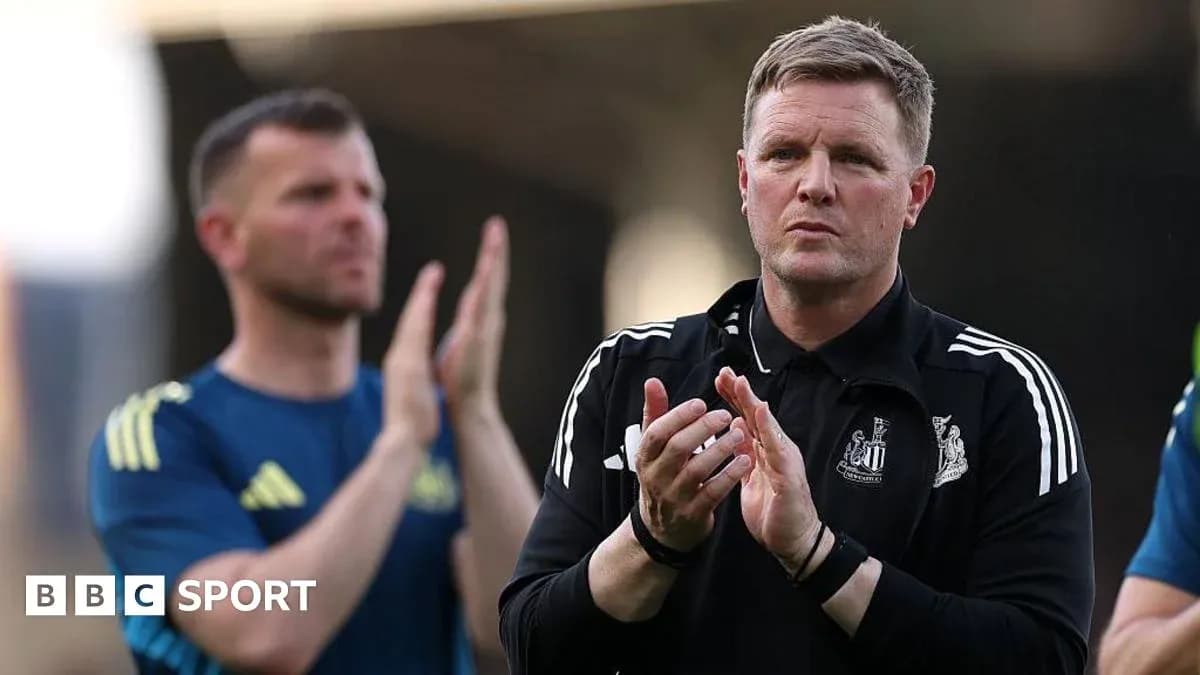 Coach clapping with player in background during match
