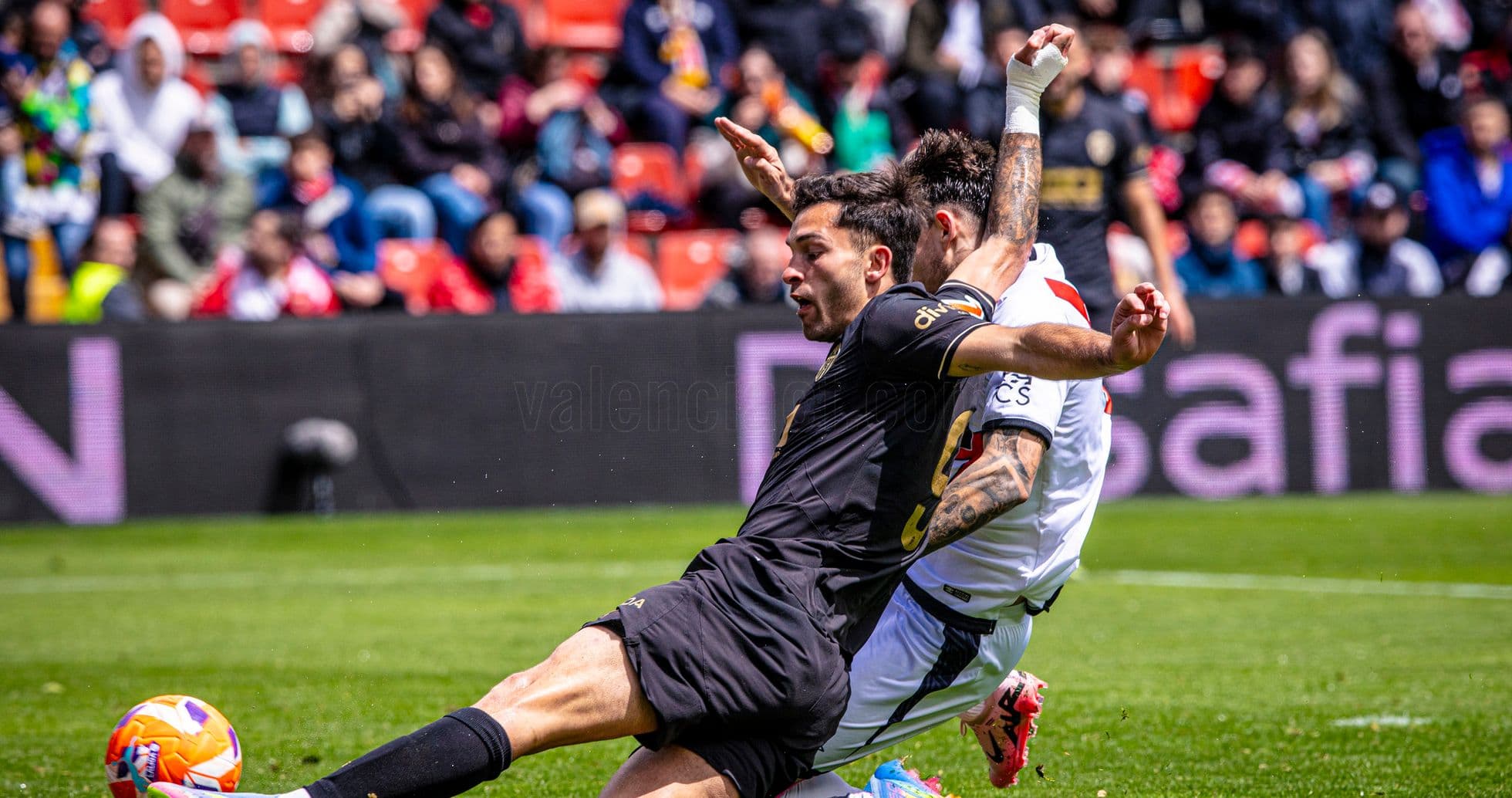 Players colliding during Valencia vs Rayo Vallecano match