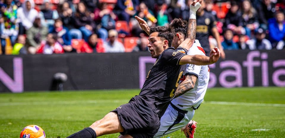 Players colliding during Valencia vs Rayo Vallecano match