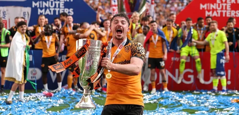 Player celebrating with trophy and confetti on pitch