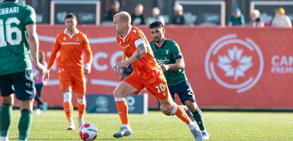 Player dribbling during Forge vs York United match