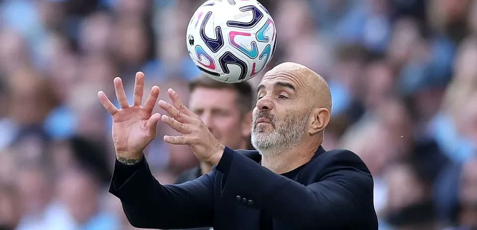 Coach attempting to catch a soccer ball during match