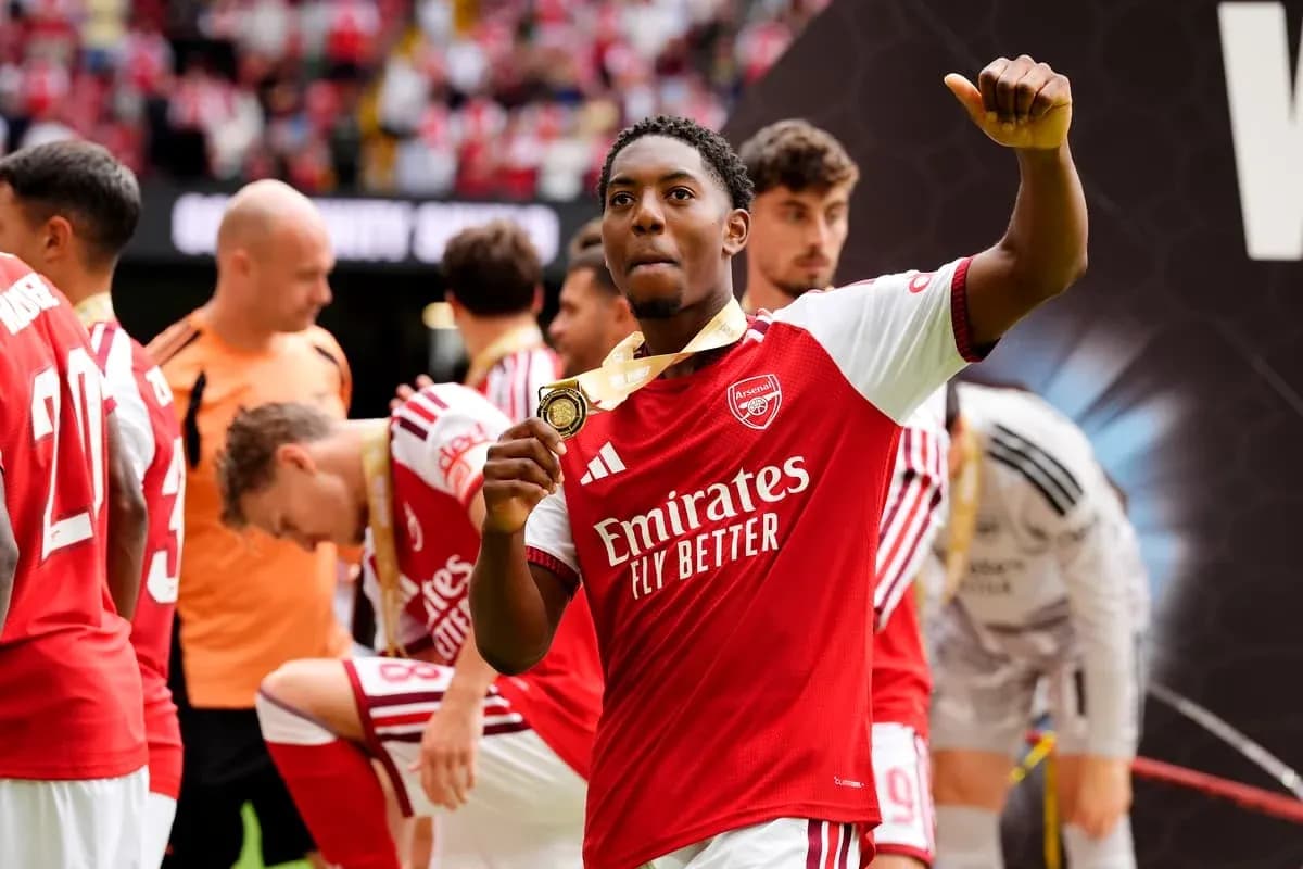 Arsenal player celebrating with a medal after match