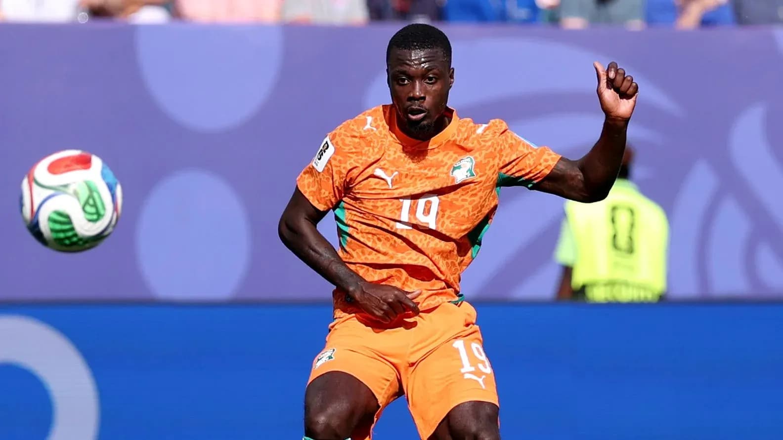Player in orange jersey controlling the soccer ball