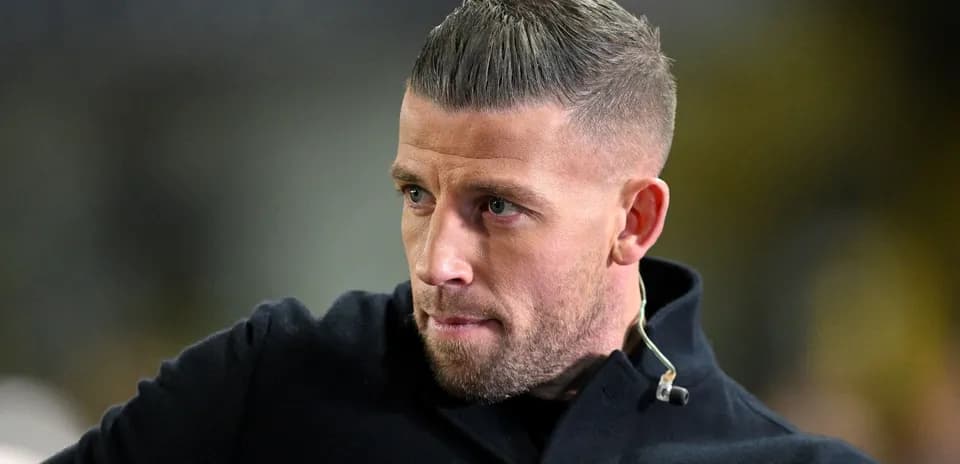 Man in a black coat looking intently