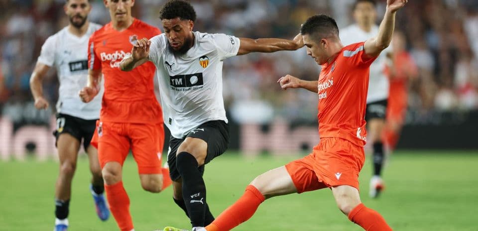 Real Sociedad player tackling Valencia opponent