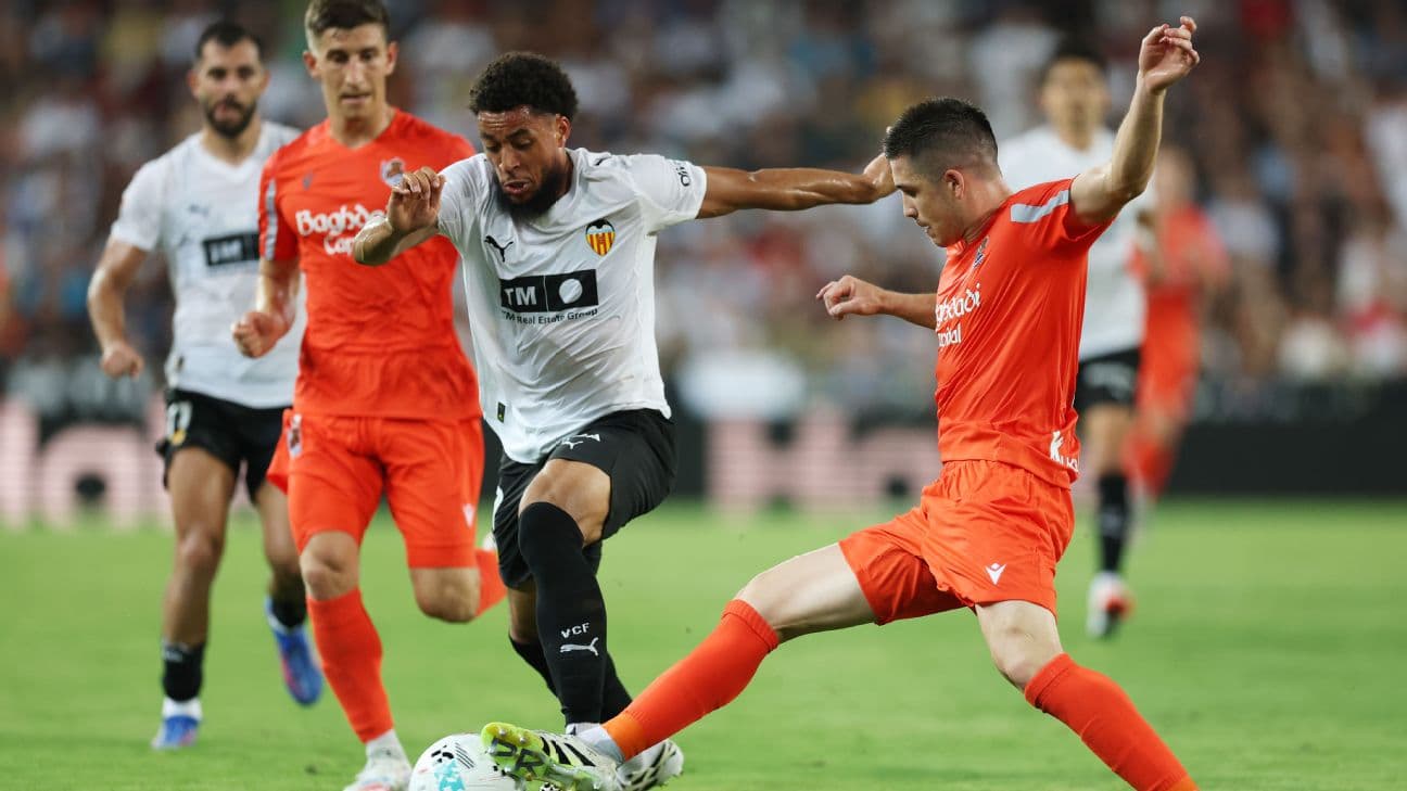 Real Sociedad player tackling Valencia opponent