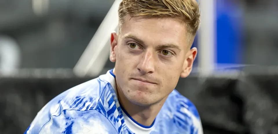 Player sitting on the bench in team jersey
