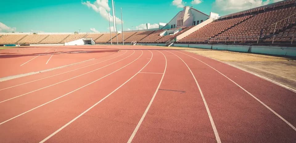 Empty running track with stadium seating in background
