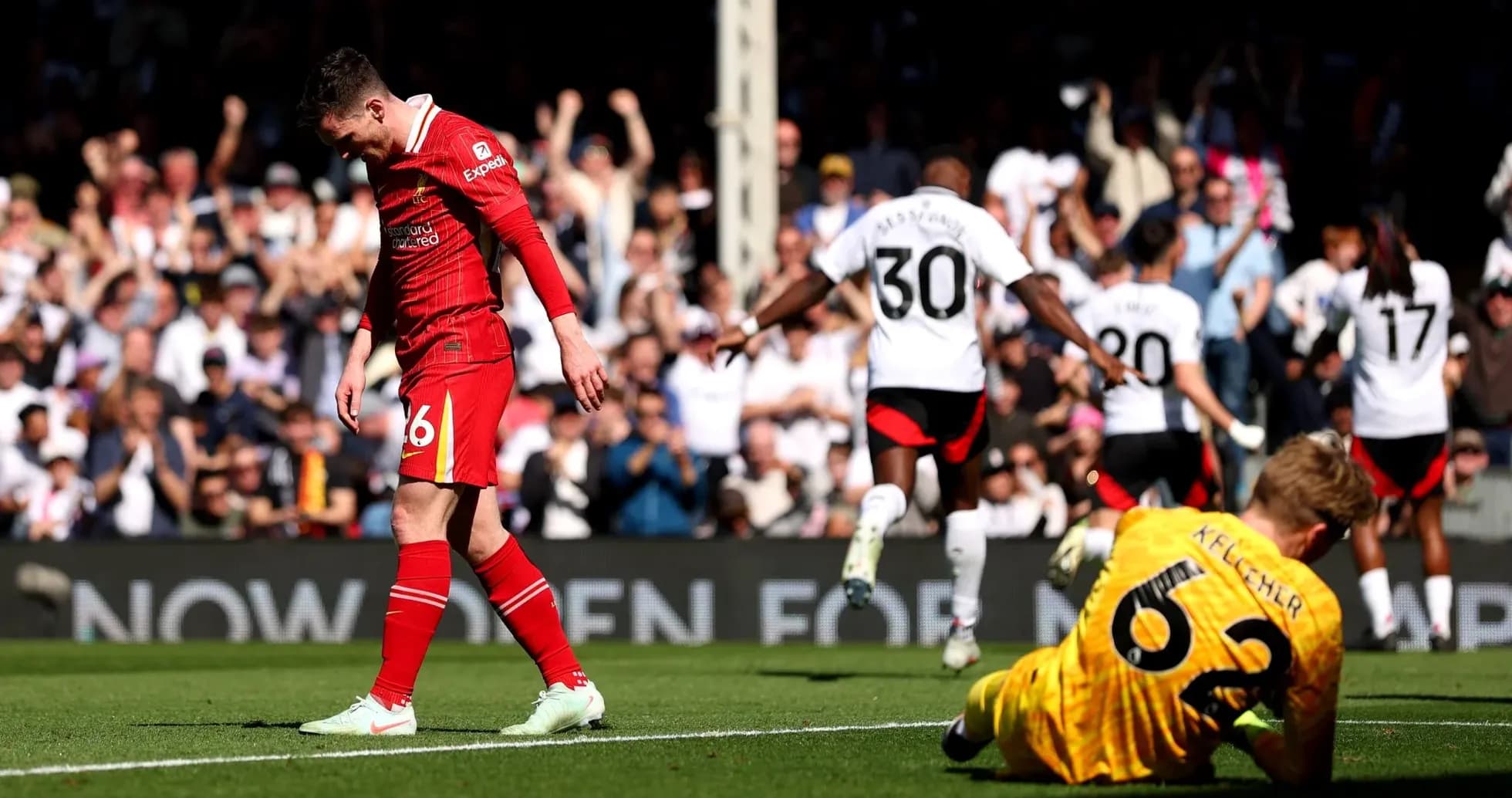 Liverpool player walks past Fulham celebrating goal