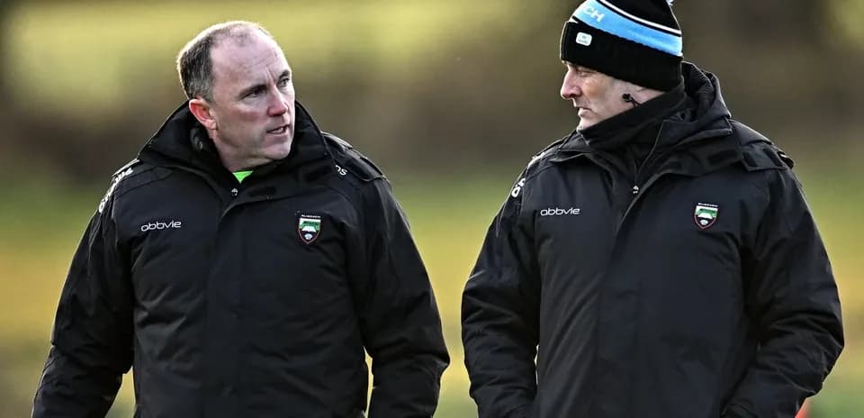 Two coaches discussing during training session outdoors