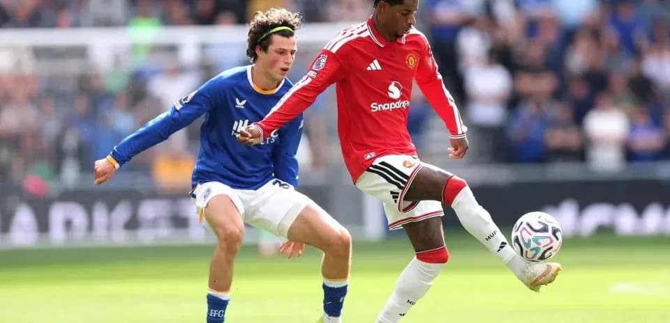 Manchester United player dribbling past opponent in match