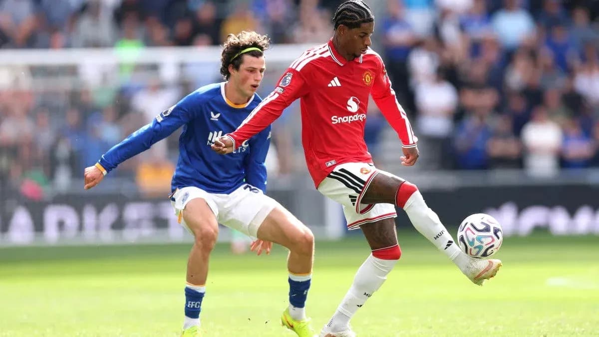 Manchester United player dribbling past opponent in match