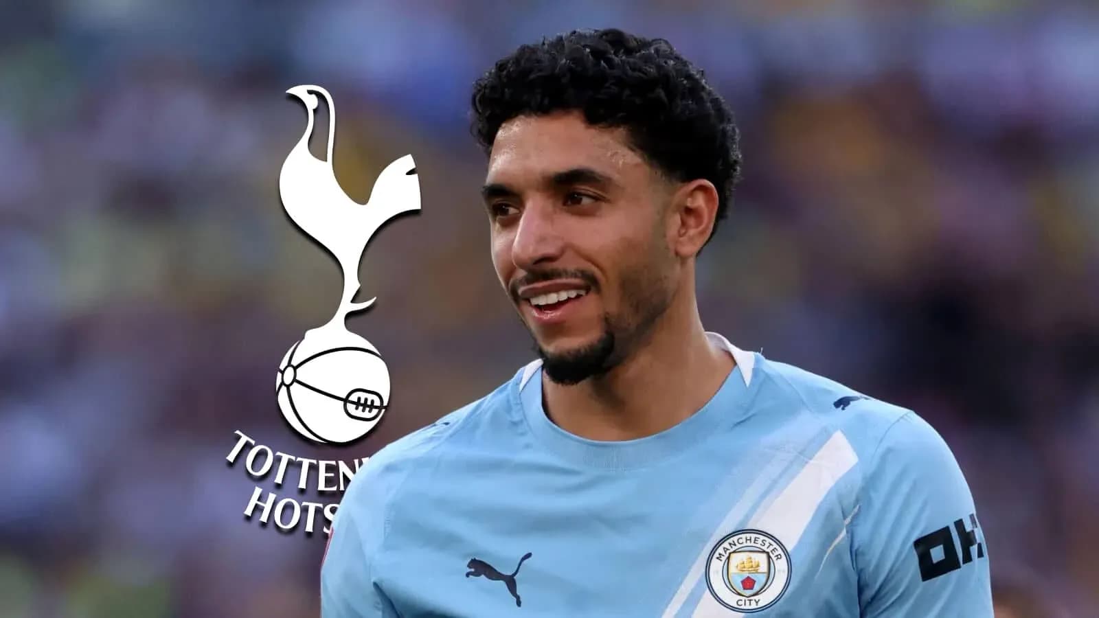 Player smiling in Manchester City jersey with logo