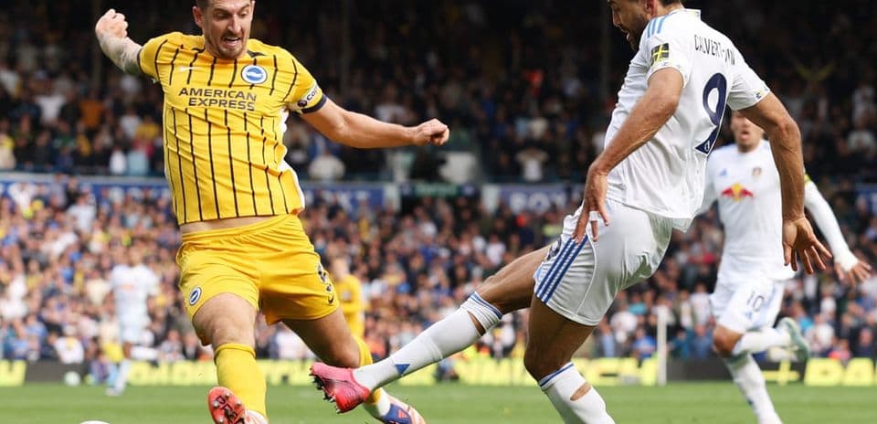 Leeds player tackling Brighton opponent during match