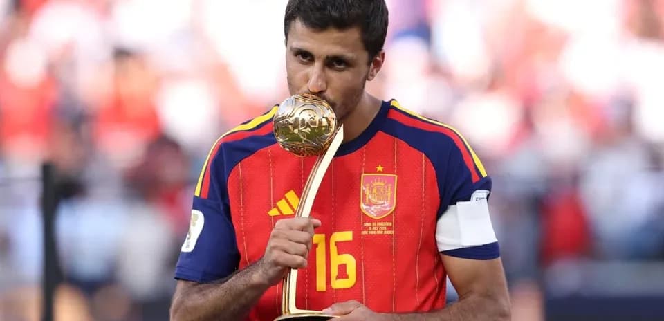 Player in Spain jersey kissing trophy on field