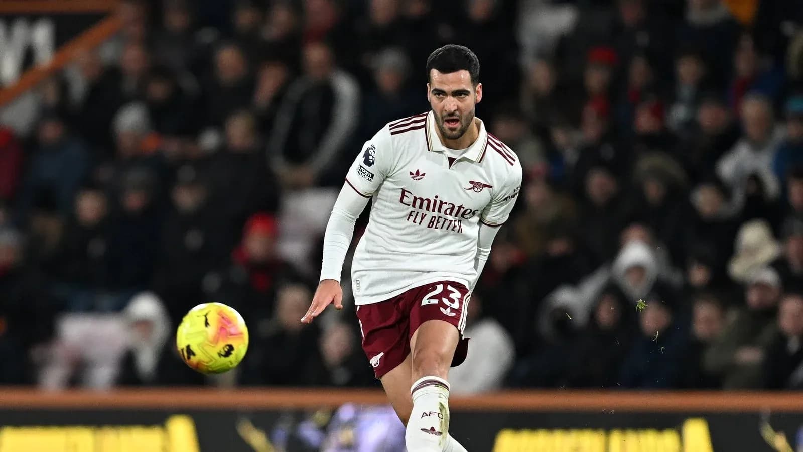 Player in Arsenal kit kicking a soccer ball