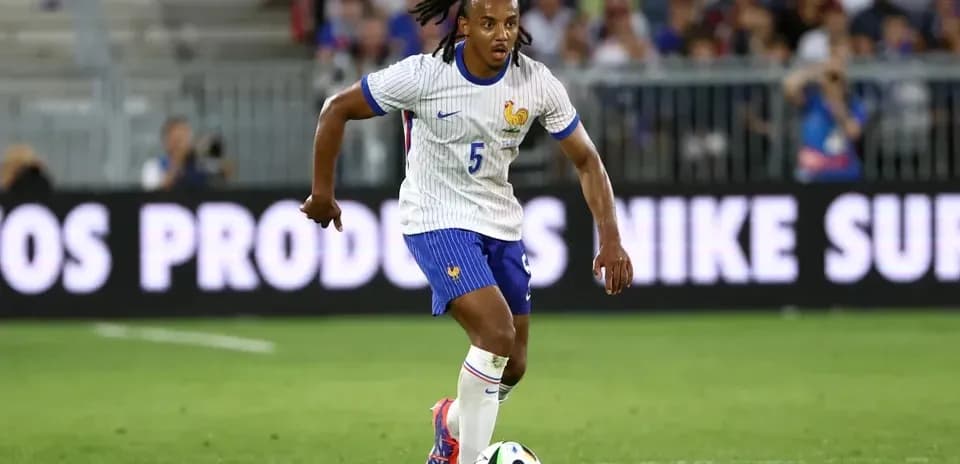 Player in France kit dribbling soccer ball on field