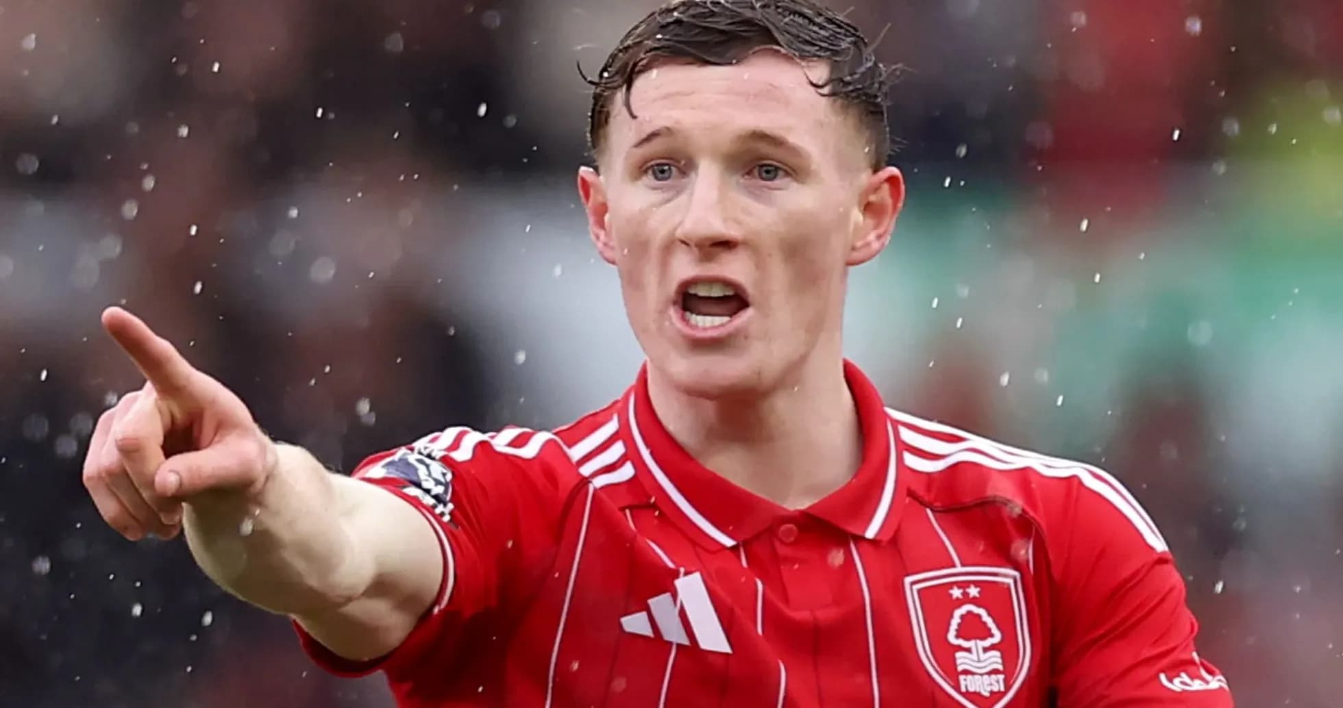 Player gesturing during a rainy football match