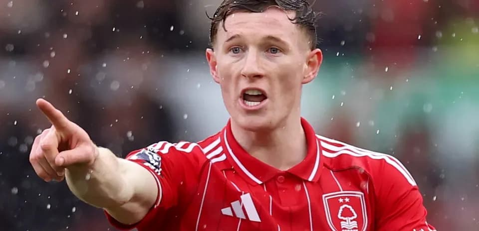 Player gesturing during a rainy football match
