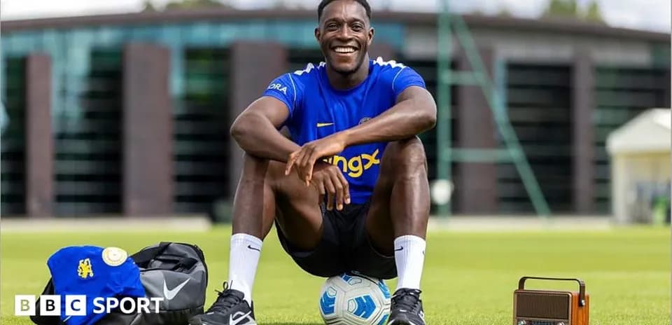 Player smiling while sitting on training ground
