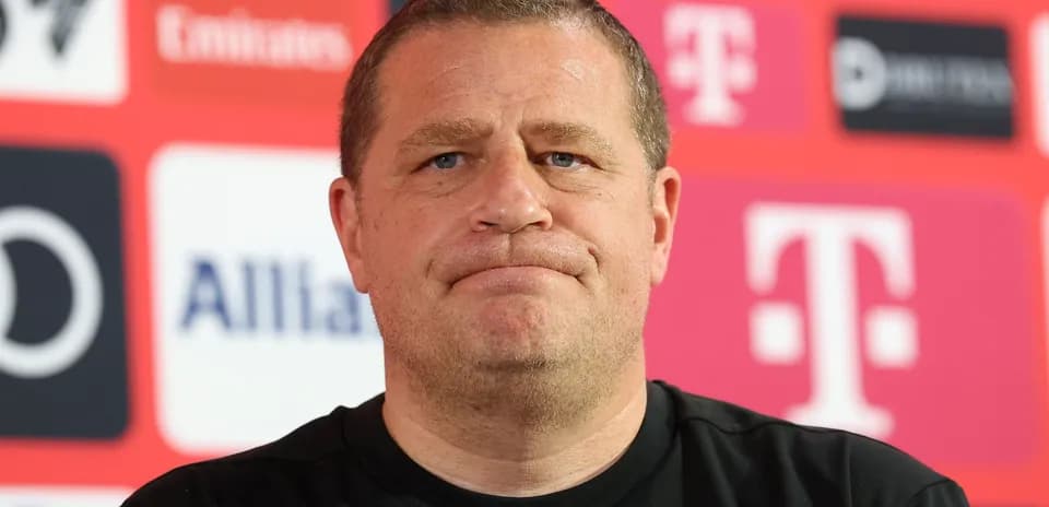 Man at press conference with sponsor logos in background