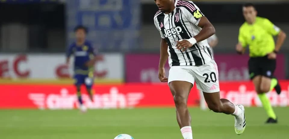 Player in Juventus kit dribbling the ball on field