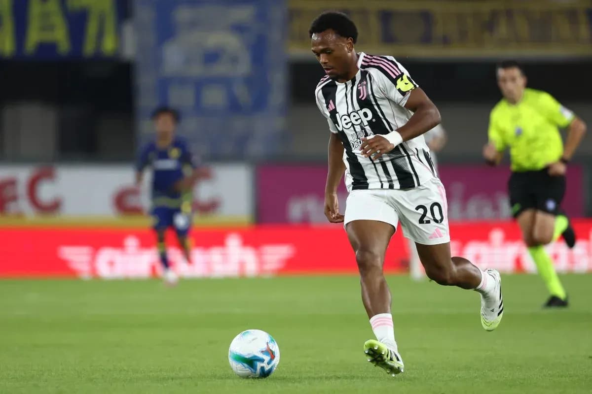 Player in Juventus kit dribbling the ball on field