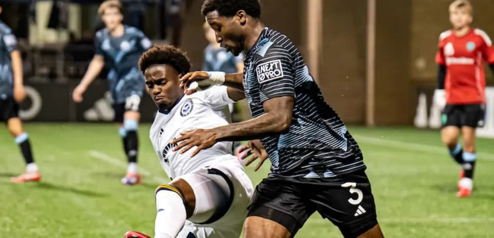 Two players battling for the ball in football match